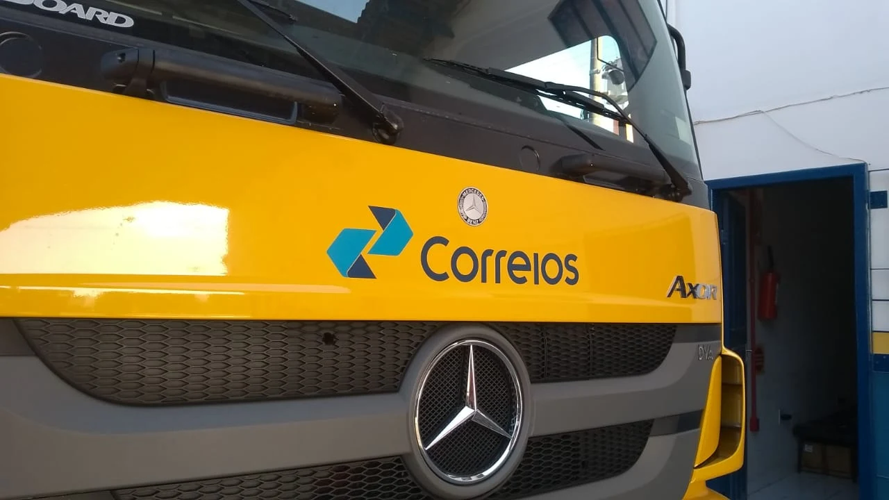 Frente de caminhão com aplicação gráfica amarela e azul dos Correios.